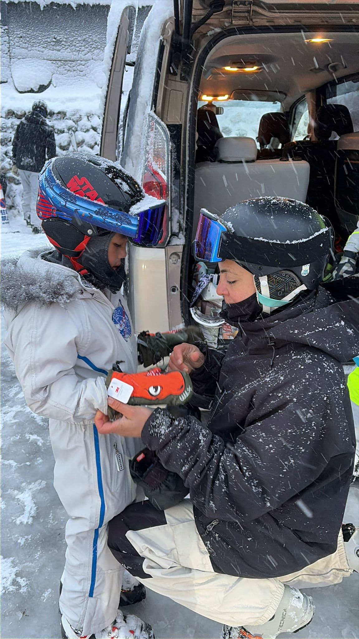 Florencia helping a child with ski equipment